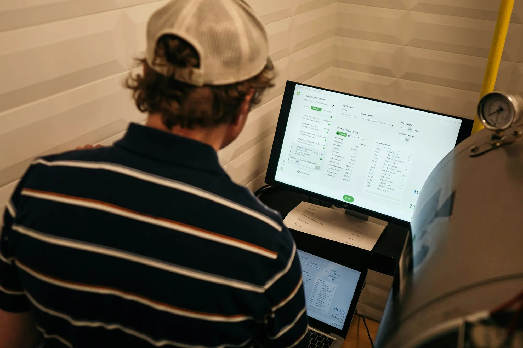 Business owner reviewing customer payment and receivables software on a monitor in a workshop